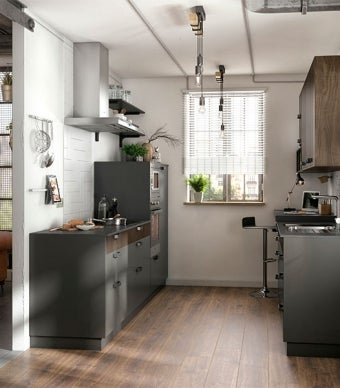 Projeto de cozinha em estilo industrial, com móveis de cozinha pretos e candeeiros suspensos industriais